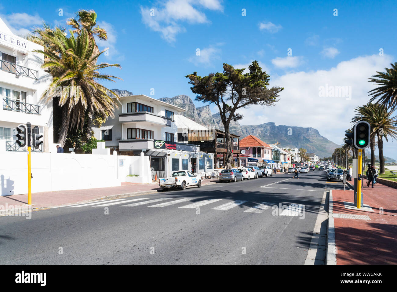 Camps Bay, exklusiven Vorort von Kapstadt, Südafrika, den Blick von der Hauptstraße in Geschäften, Restaurants und Wohnhäuser an einem Frühlingstag Stockfoto