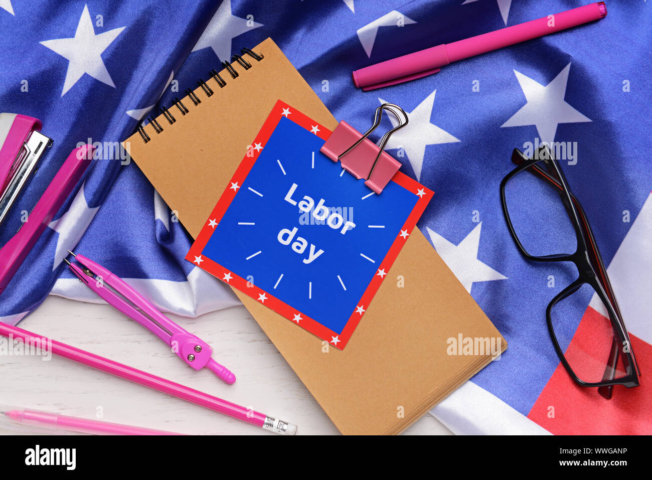 Schreibwaren, USA-Flagge und Karte mit Text TAG DER ARBEIT auf hellen Hintergrund Stockfoto