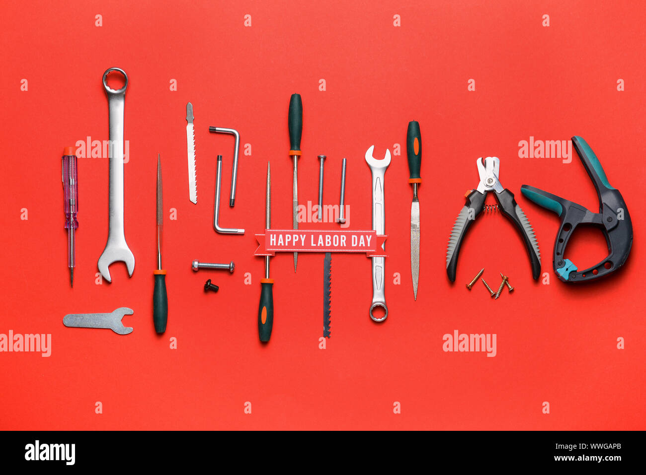 Satz von Tools und Text HAPPY TAG DER ARBEIT auf farbigen Hintergrund Stockfoto