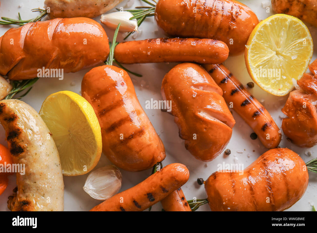 Auswahl an leckeren gegrillten Würstchen auf hellen Hintergrund Stockfoto