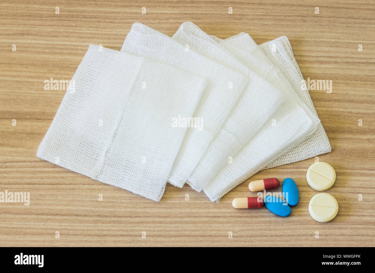 Weiß Mulltupfer und Medikamente auf hölzernen Hintergrund Stockfoto Weiß Mulltupfer und Medikamente auf hölzernen Hintergrund Stockfoto