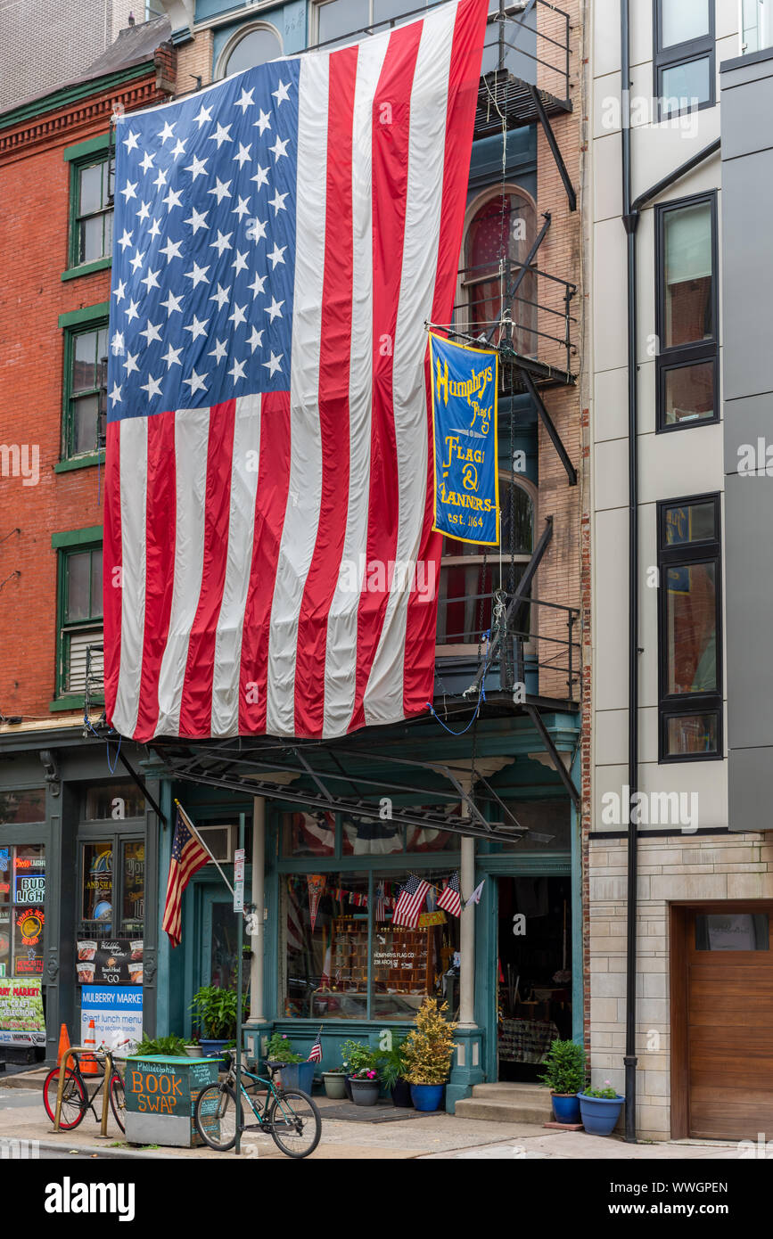 Eine gigantische Sterne und Streifen Flagge Vorhänge über dem Feuer auf der Vorderseite der Flaggen & des Humphry Banner Shop mit 238 Arch St, die Termine von 1864 Stockfoto