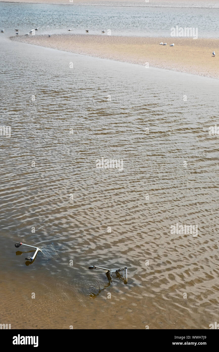 Metall Trolleys liegen in einem englischen Fluss aufgegeben. Wasserverschmutzung der verschiedenen Typen hat ein zunehmendes Problem national und international werden Stockfoto