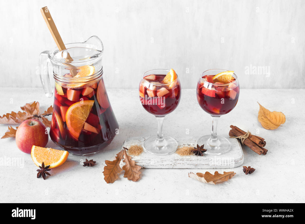 Herbst Sangria oder Punch in Krug. Hausgemachten Rotwein Obst Sangria und gelbe Herbstliche Blätter auf weißem Hintergrund, kopieren. Stockfoto