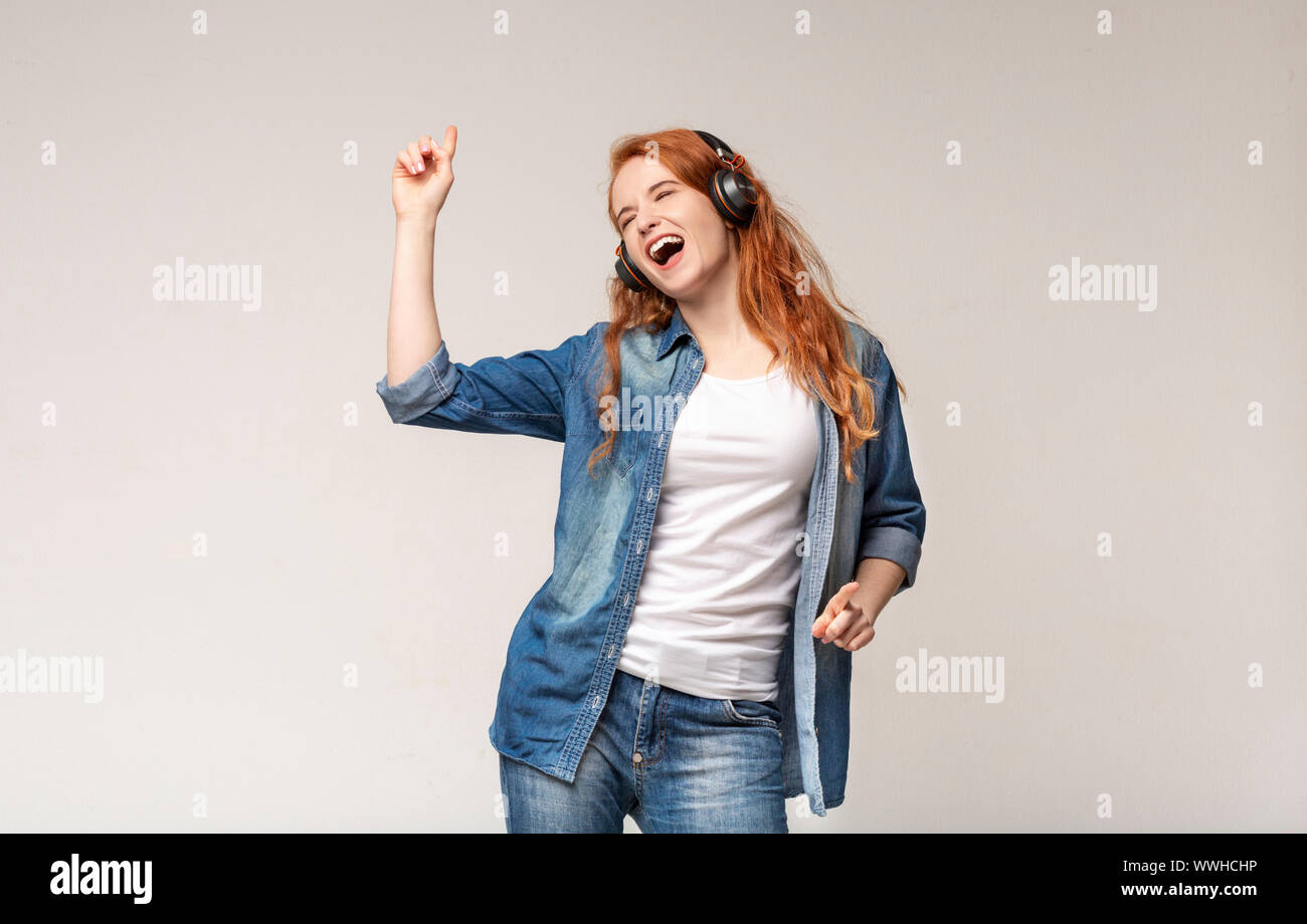 Energetische jugendlich Mädchen singen, Hören von Musik über Kopfhörer Stockfoto
