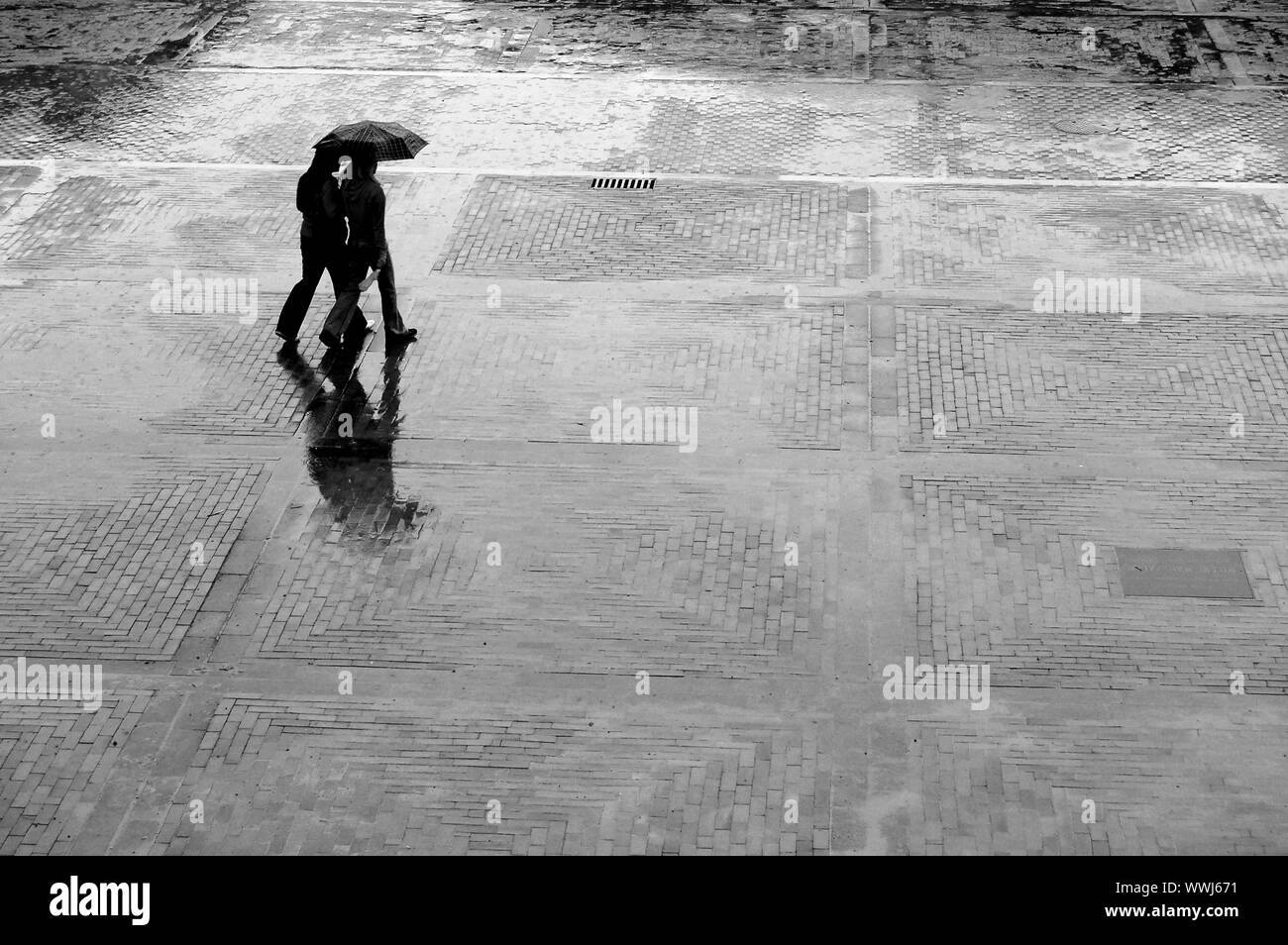Zwei Frauen mit Schirm wandern im Regen Stockfoto