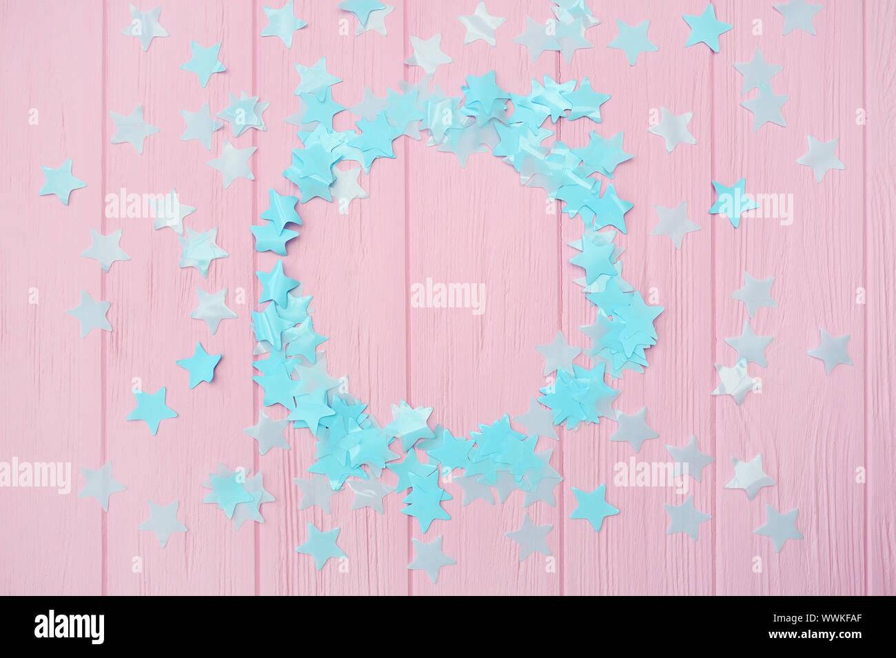 Blue Stars Konfetti auf einem rosa Hintergrund aus Holz mit runden Rahmen Platz für Ihren Text, Design Grußkarten und Einladungen Stockfoto