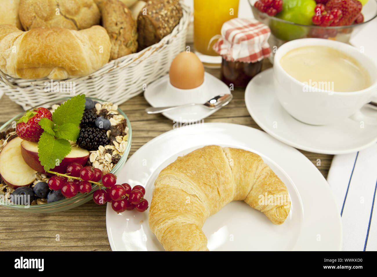 Französisches Frühstück mit Croissants, Saft und Marmelade auf einem Tisch Stockfoto