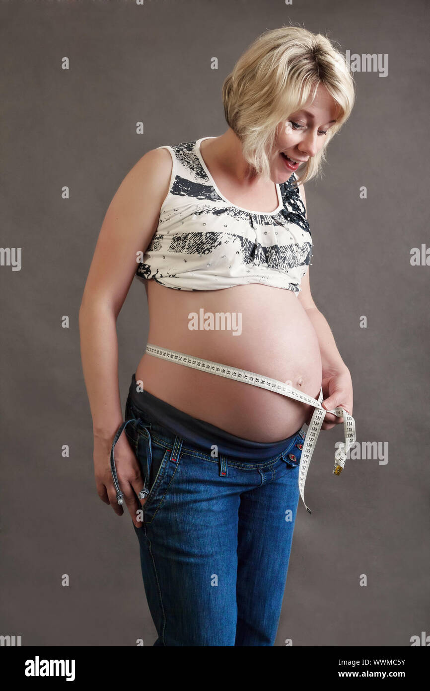 Schöne schwangere Frau zärtlich ihren Bauch messen Stockfoto