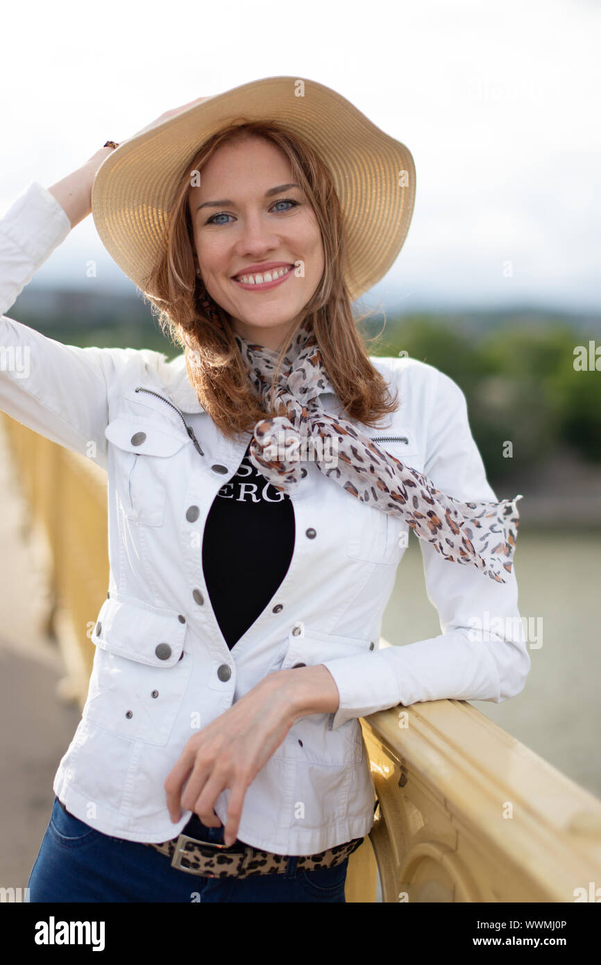 Junge Schönheit urban Frau in Hut lächelnd auf Brücke Stockfoto