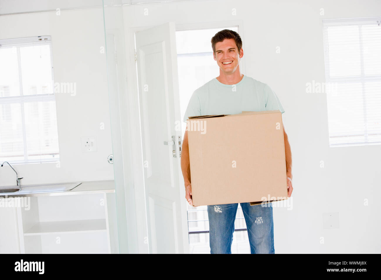 Mann mit Umzug in die neue Heimat lächelnd-box Stockfoto