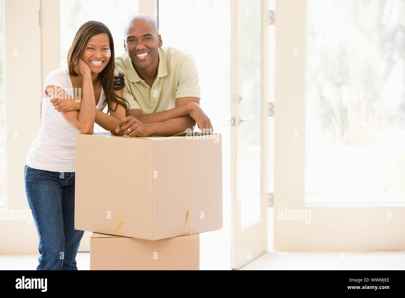 Paar mit Boxen im neuen Hause lächelnd Stockfoto