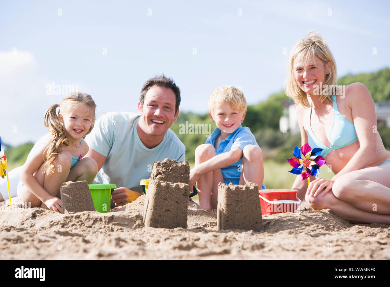 Familie am Strand Sandburgen Lächeln machen Stockfoto