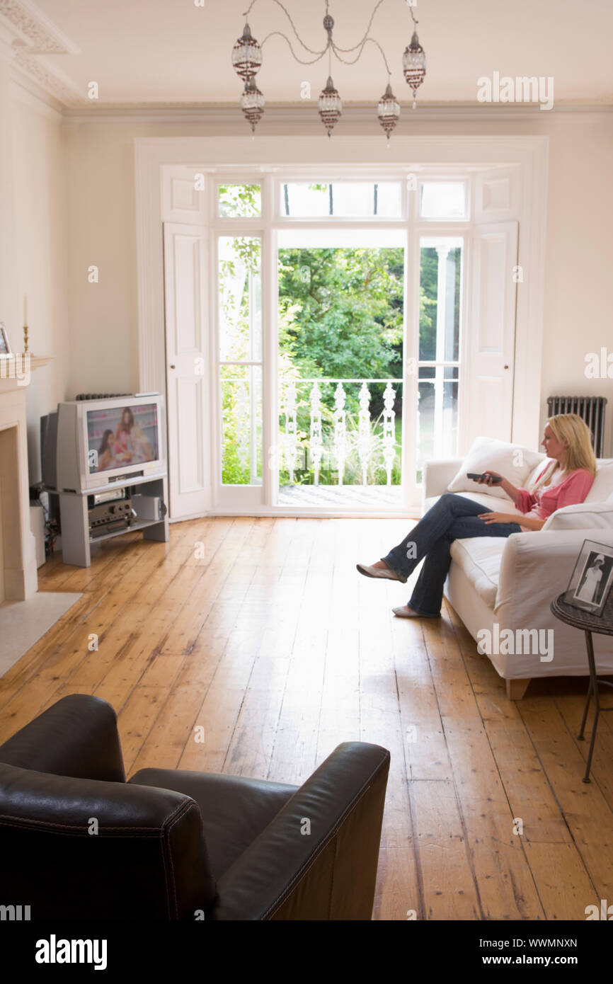 Frau im Wohnzimmer vor dem Fernseher Stockfoto