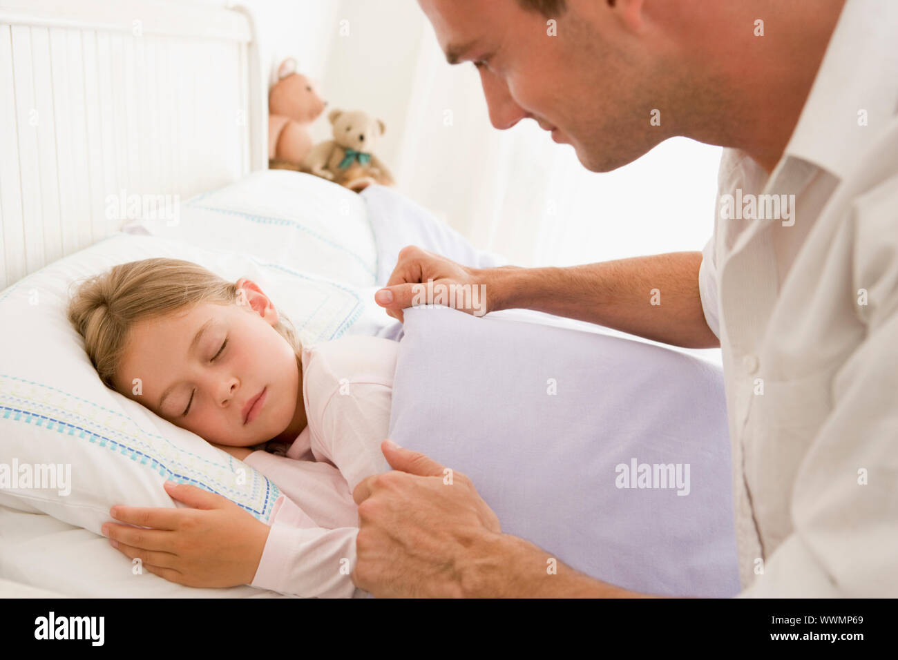 Mann junges Mädchen im Bett Lächeln aufwachen Stockfoto