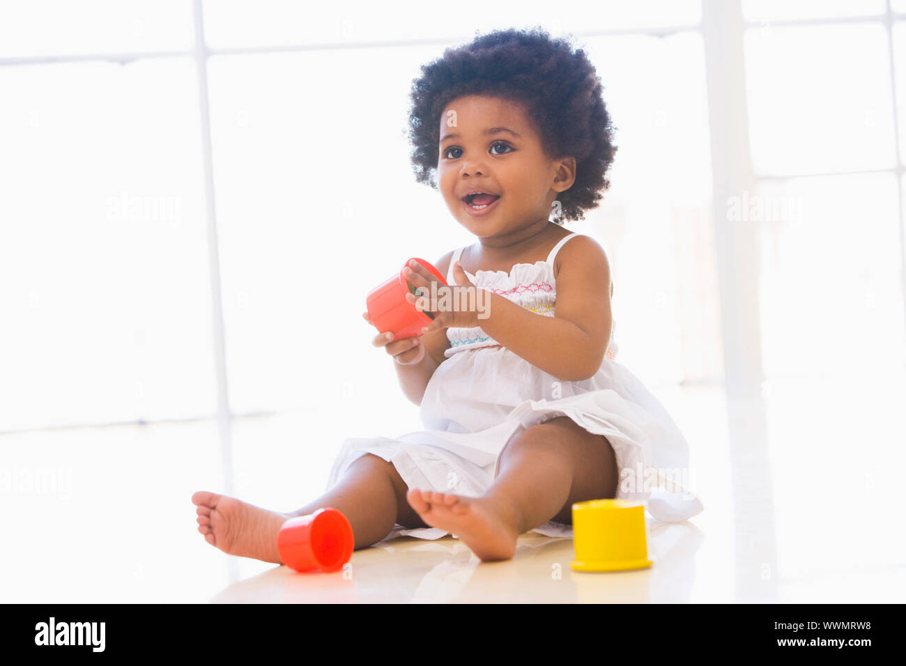 Baby drinnen spielen mit Cup-Spielzeug Stockfoto