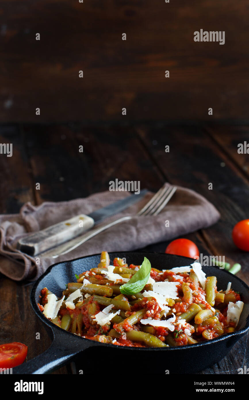 Bohnen mit Tomaten Eintopf in der Nähe auf einem dunklen Tabelle Stockfoto