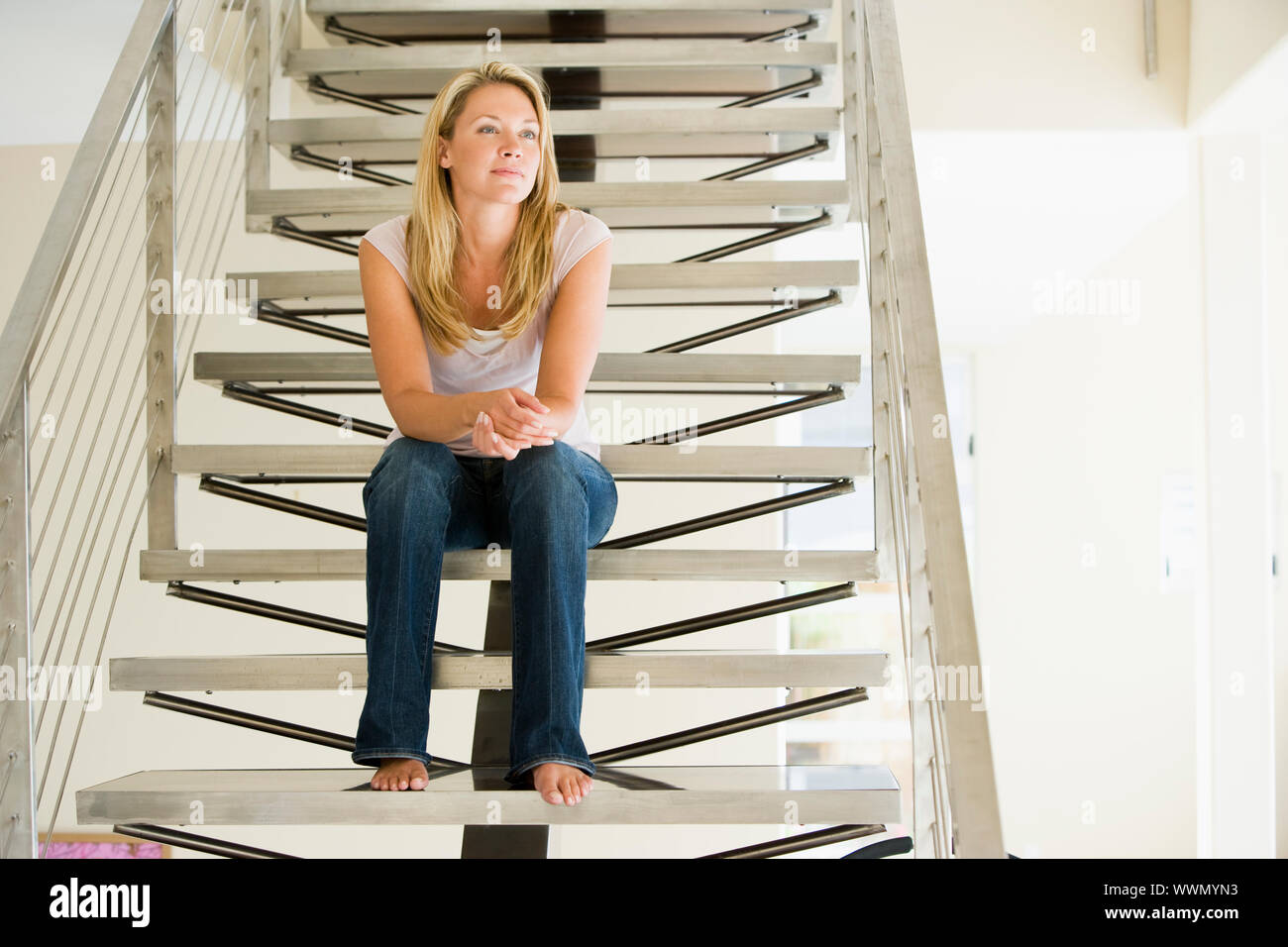 Frau sitzt auf der Treppe Stockfoto