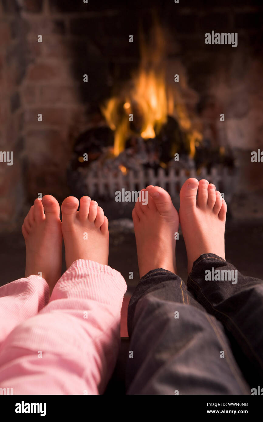 Kinderfüße Erwärmung am Kamin Stockfoto