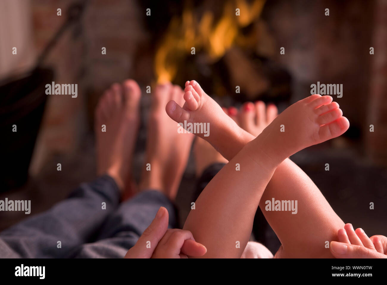 Familie der Füße Erwärmung am Kamin Stockfoto