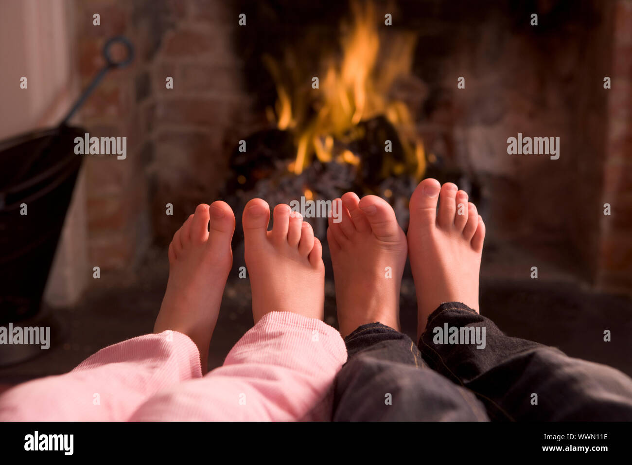 Kinderfüße Erwärmung am Kamin Stockfoto