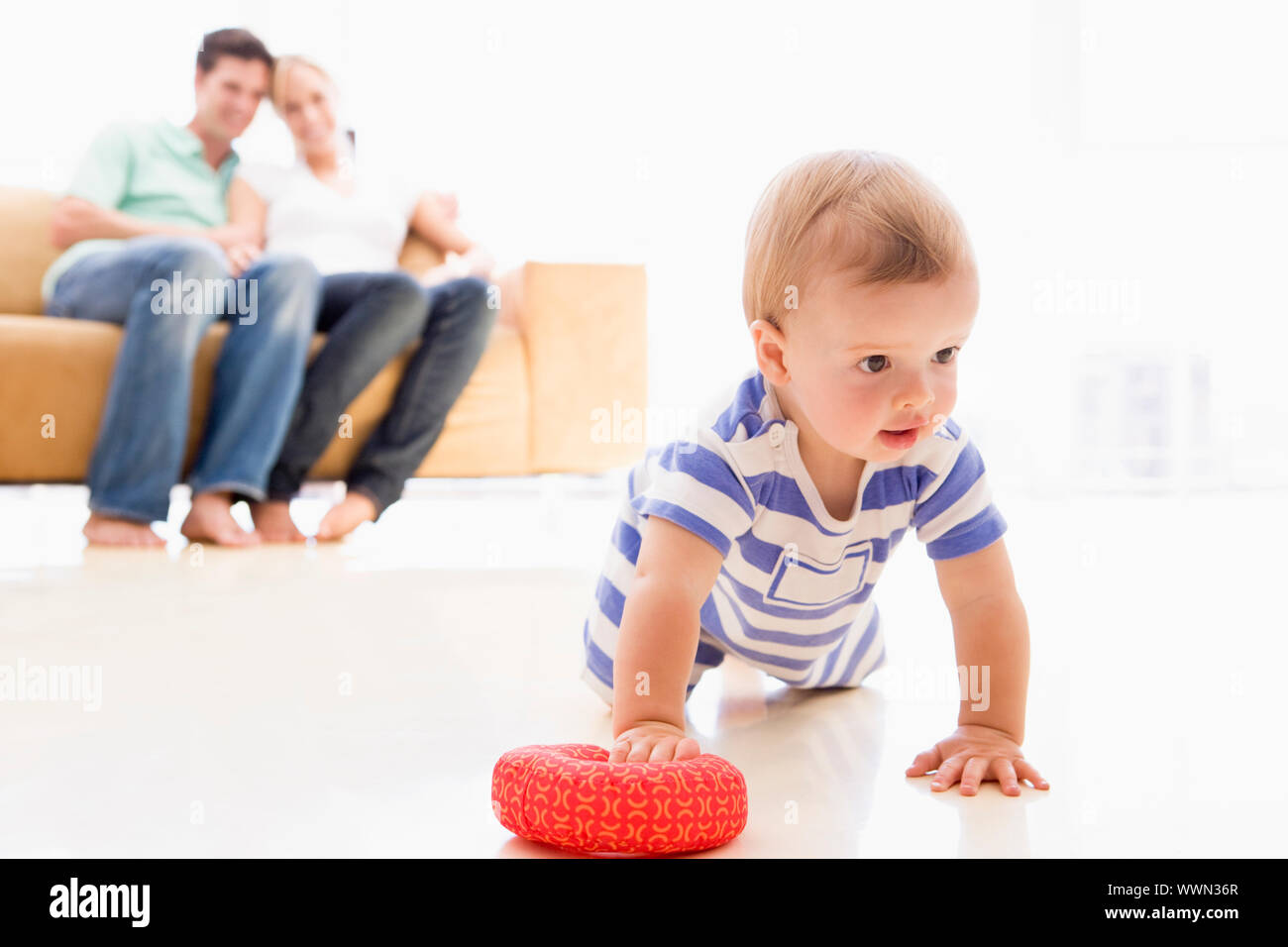 Paar im Wohnzimmer mit Baby Lächeln Stockfoto