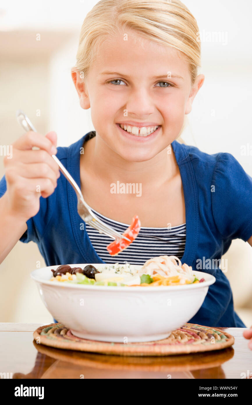 Junges Mädchen im Haus essen Meeresfrüchte lächelnd Stockfoto