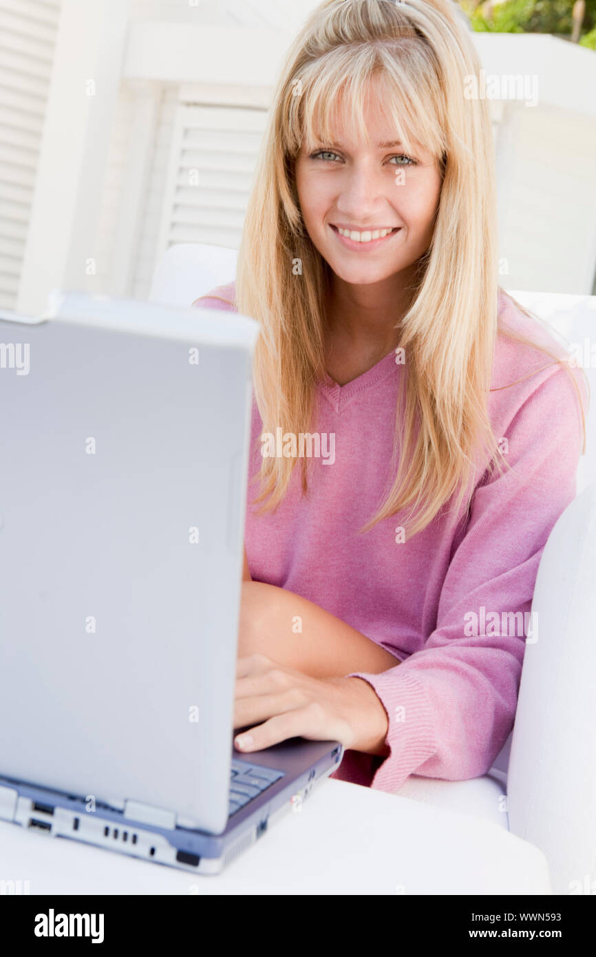 Frau auf der Terrasse mit Laptop lächelnd Stockfoto