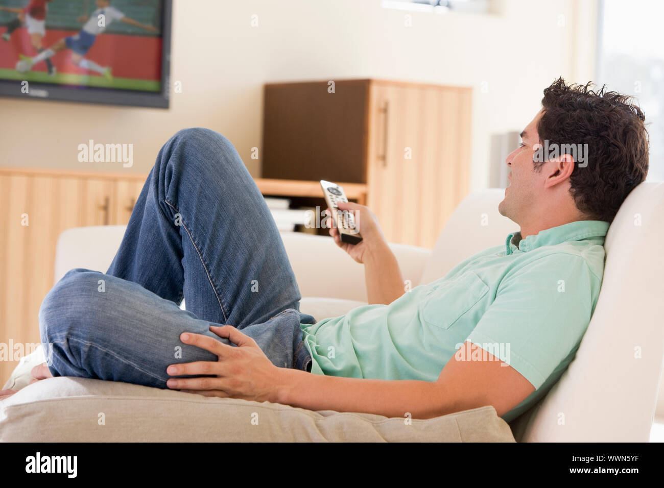 Mann im Wohnzimmer vor dem Fernseher Stockfoto