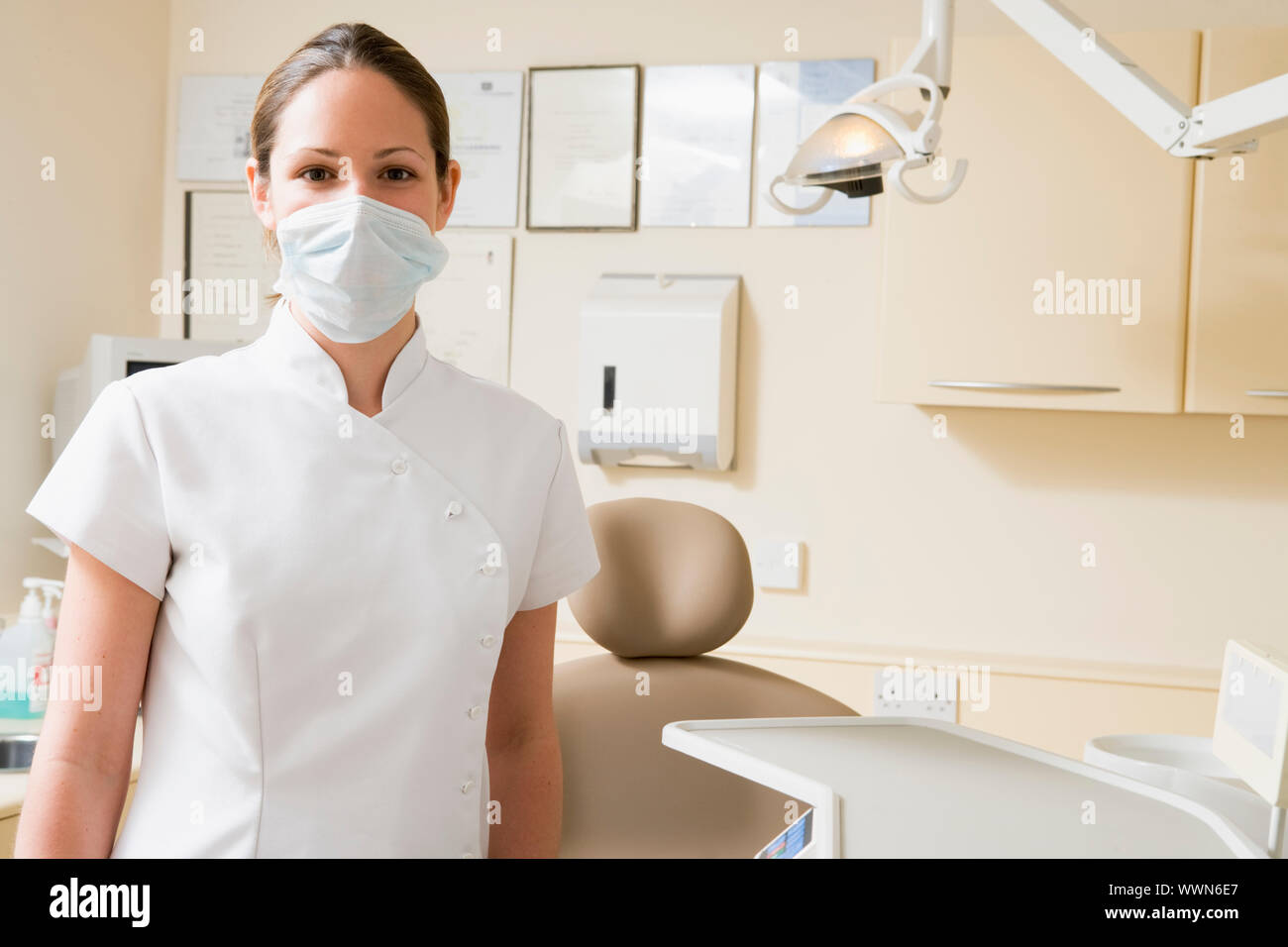 Zahnarzthelferin in Untersuchungszimmer mit Maske auf Stockfoto