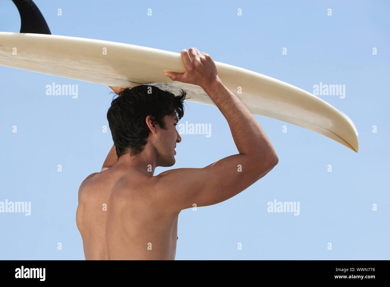 Surfer mit Brett am Kopf Stockfoto