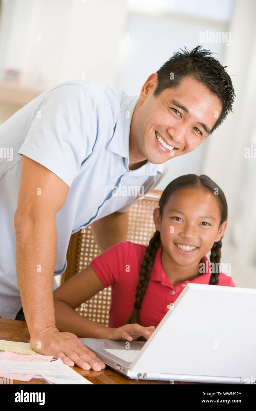 Mann und junge Mädchen mit Laptop im Speisesaal Lächeln Stockfoto