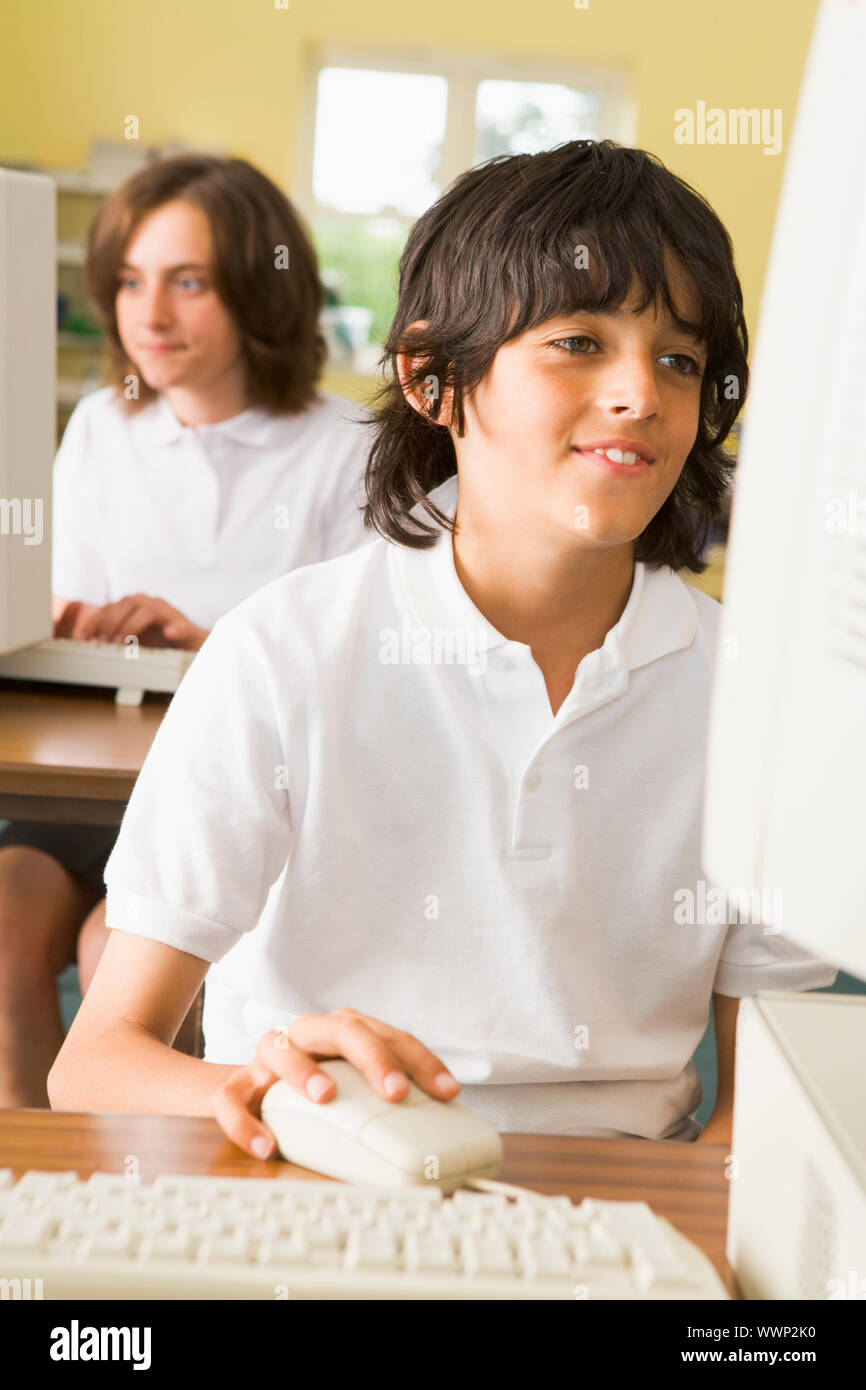 Student an der Computer-terminal eingeben mit Studenten im Hintergrund (Tiefenschärfe) Stockfoto