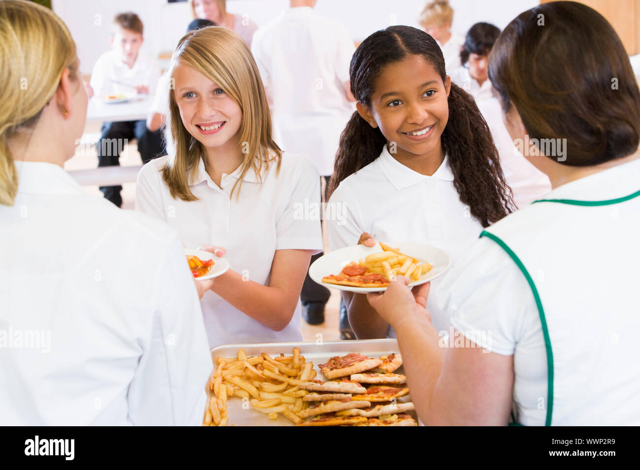 Schüler in der Cafeteria Linie von Mittagessen Damen serviert wird Stockfoto