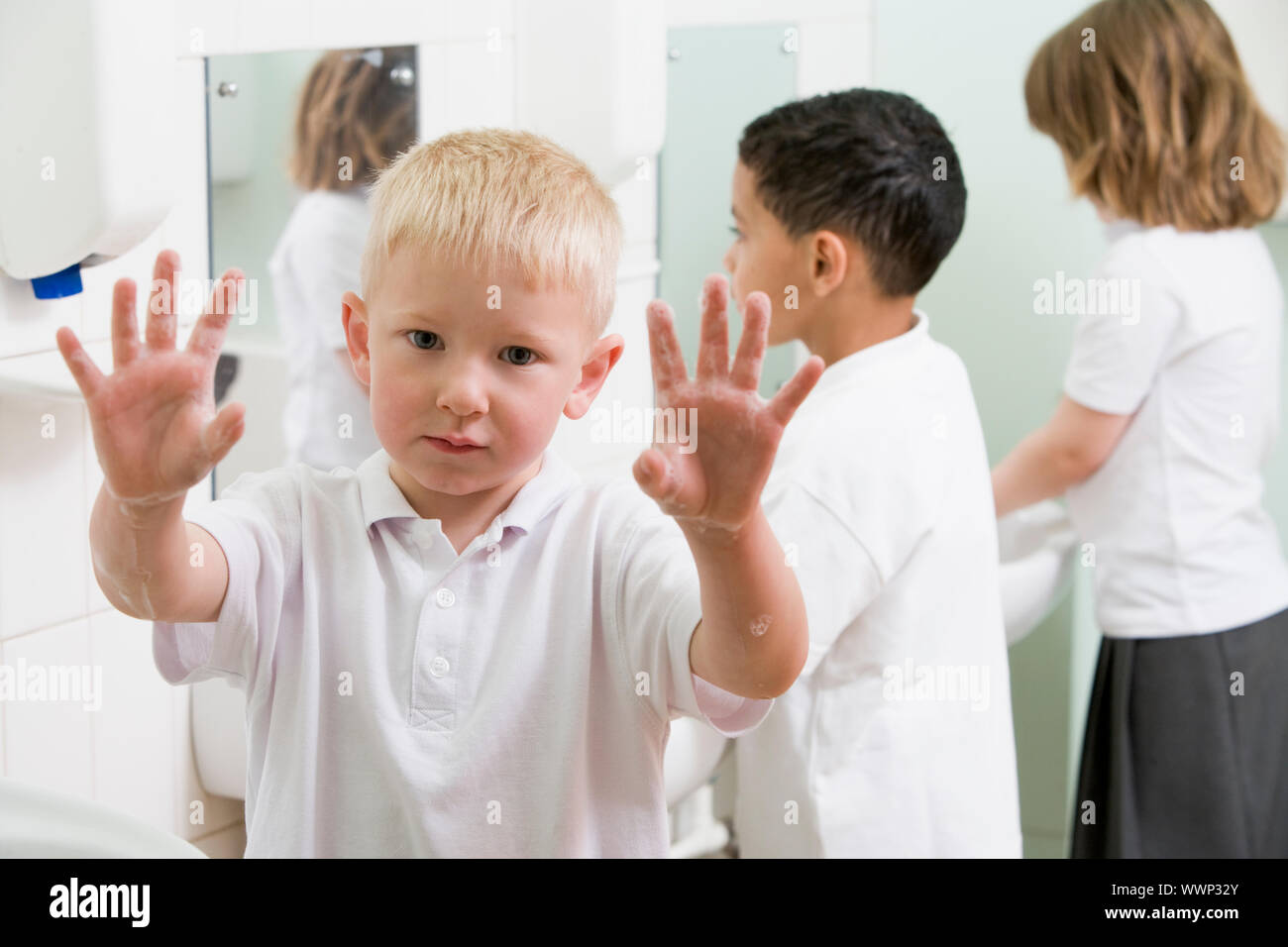 Studenten im Bad am Waschbecken waschen der Hände mit einem hochhalten seifigen Händen (Tiefenschärfe) Stockfoto