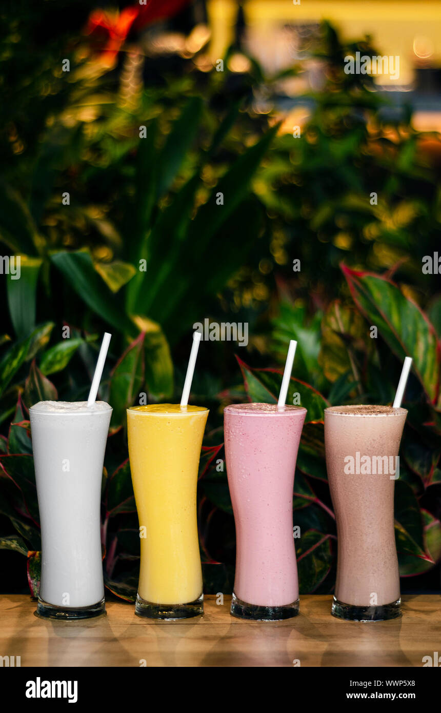 Gemischte organische Kokosnuss, Erdbeere, Schokolade und Mango Eis Milchshakes Stockfoto