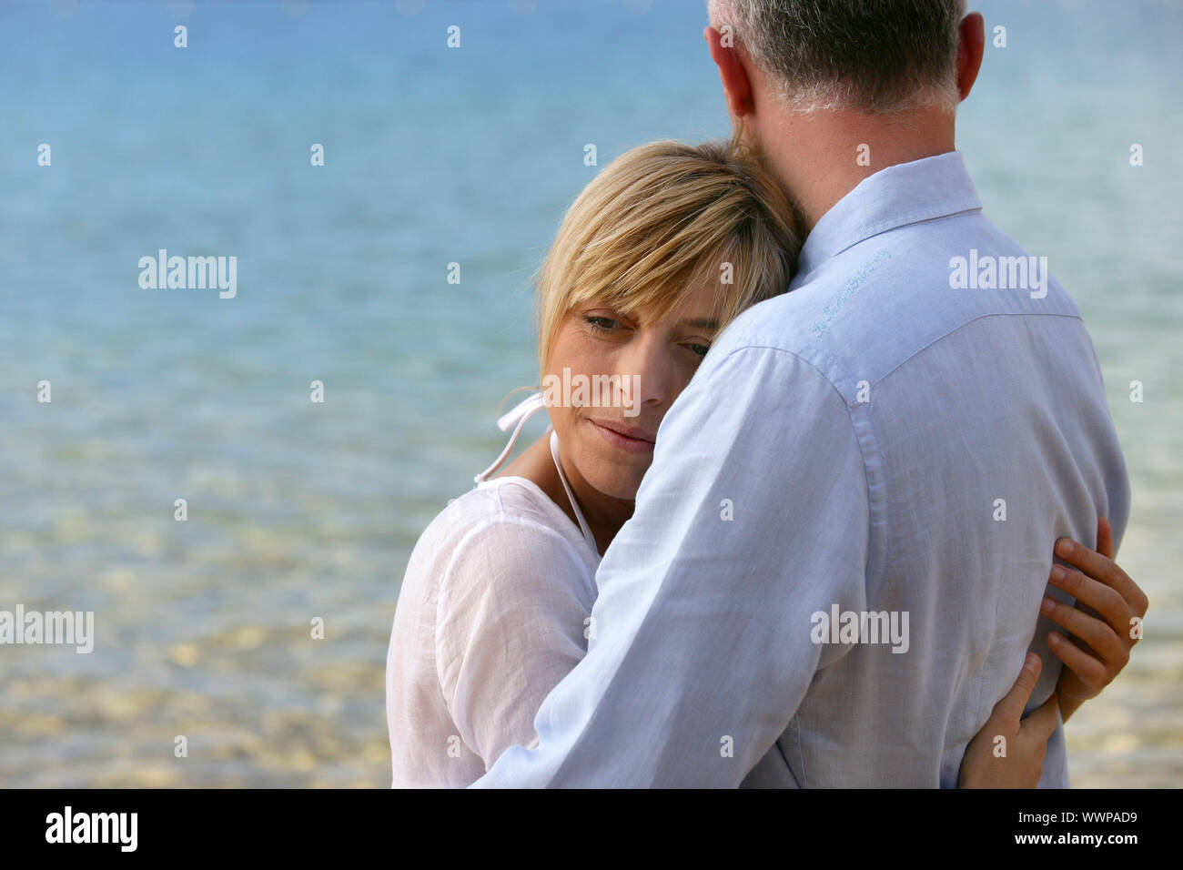 blonde Frau, ihr Mann umarmt Stockfoto