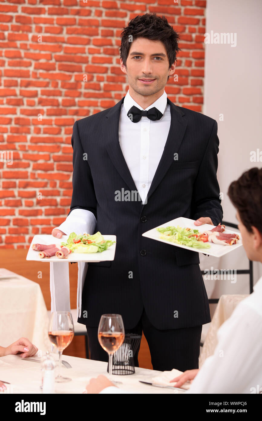 Kellner, die Bereitstellung von Mahlzeiten für Tabelle Stockfoto