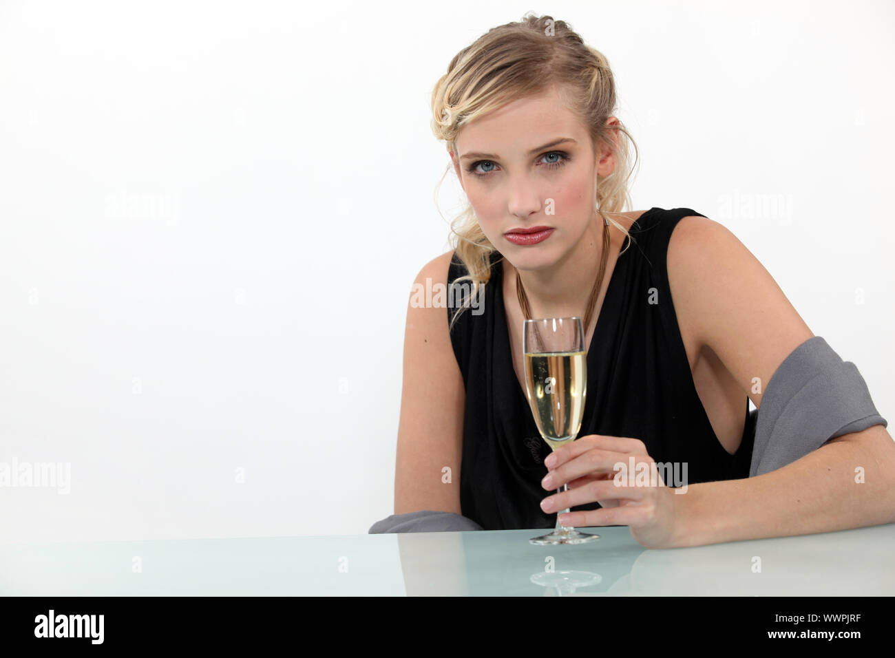 Weinende Frau trinkt ein Glas Champagner Stockfoto