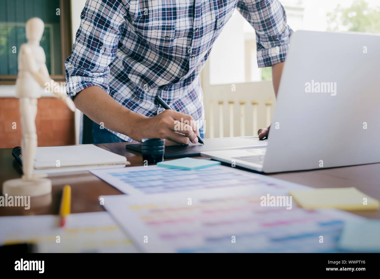 Grafiker und Fotograf arbeitet auf dem Computer und verwendet Grafiktablett. Stockfoto