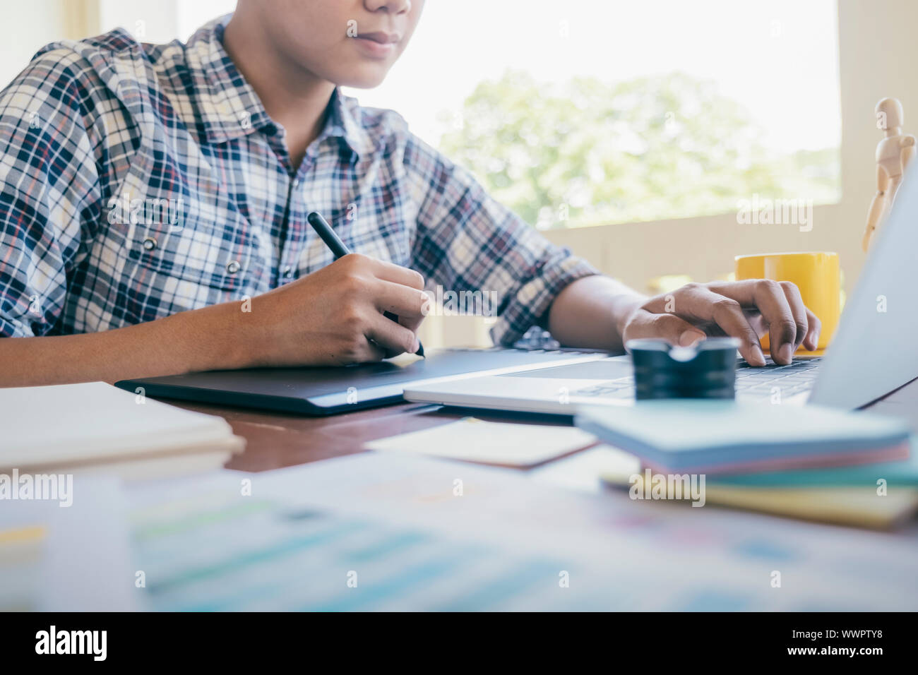 Grafiker und Fotograf arbeitet auf dem Computer und verwendet Grafiktablett. Stockfoto