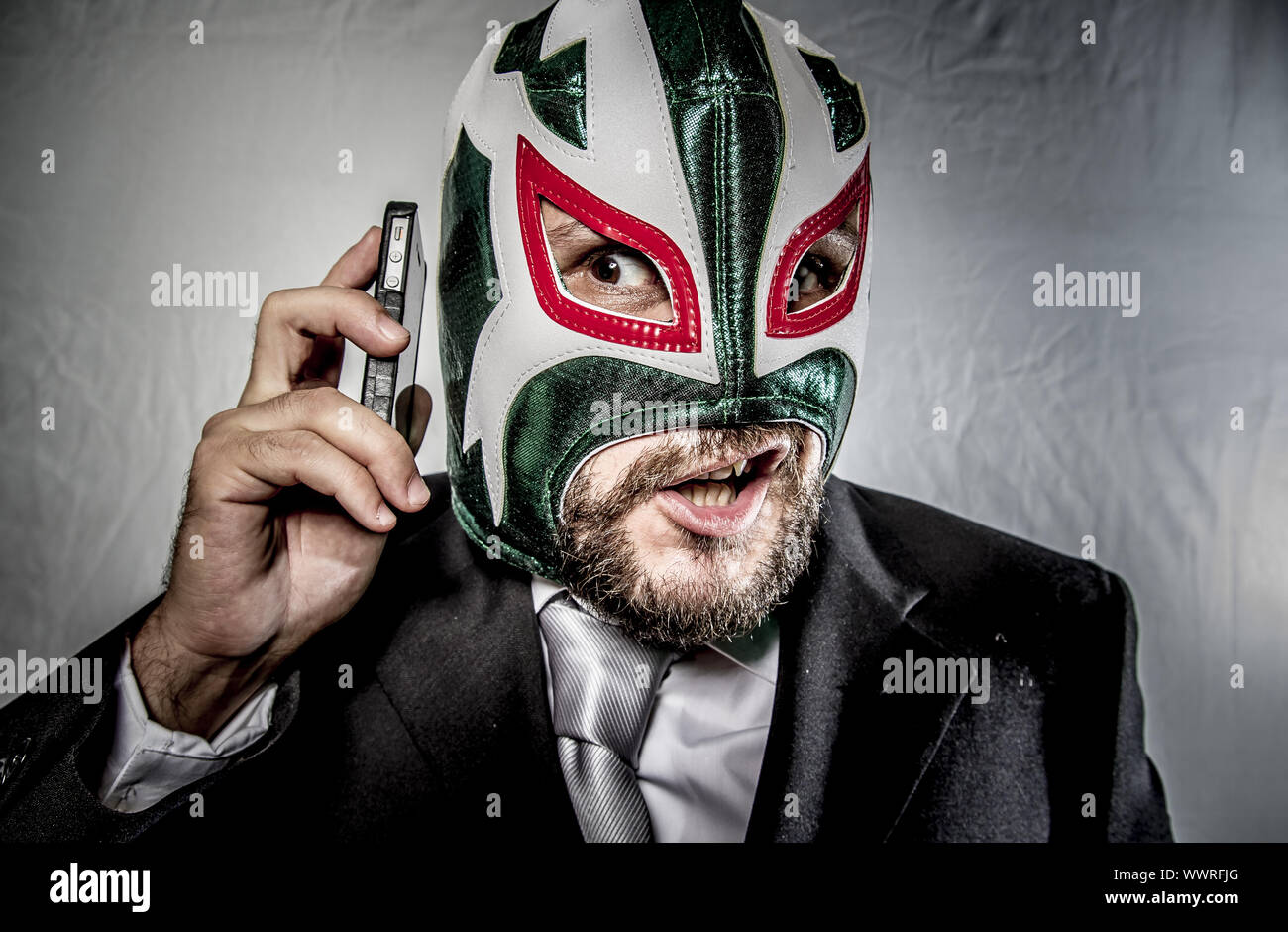 Ärger, wütend Geschäftsmann mit Maske des mexikanischen Kämpfer, gekleidet in Anzug und Krawatte Stockfoto