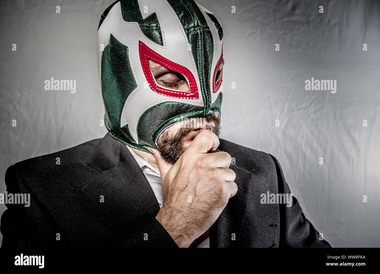 Unzufrieden, wütend Geschäftsmann mit Maske des mexikanischen Kämpfer, gekleidet in Anzug und Krawatte Stockfoto