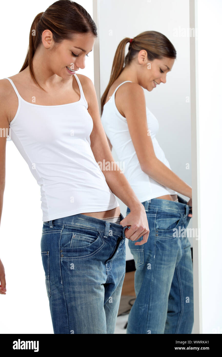magere junge Frau zieht oben auf ihrem Jean, zu groß für Ihr  Stockfotografie - Alamy