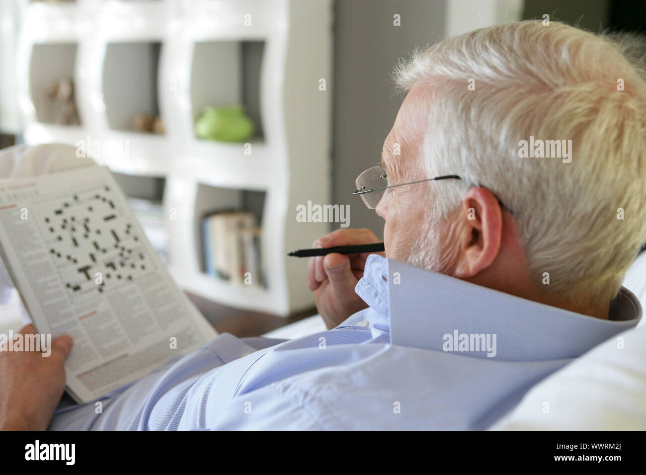 Ältere Mann tut Kreuzworträtsel Stockfoto