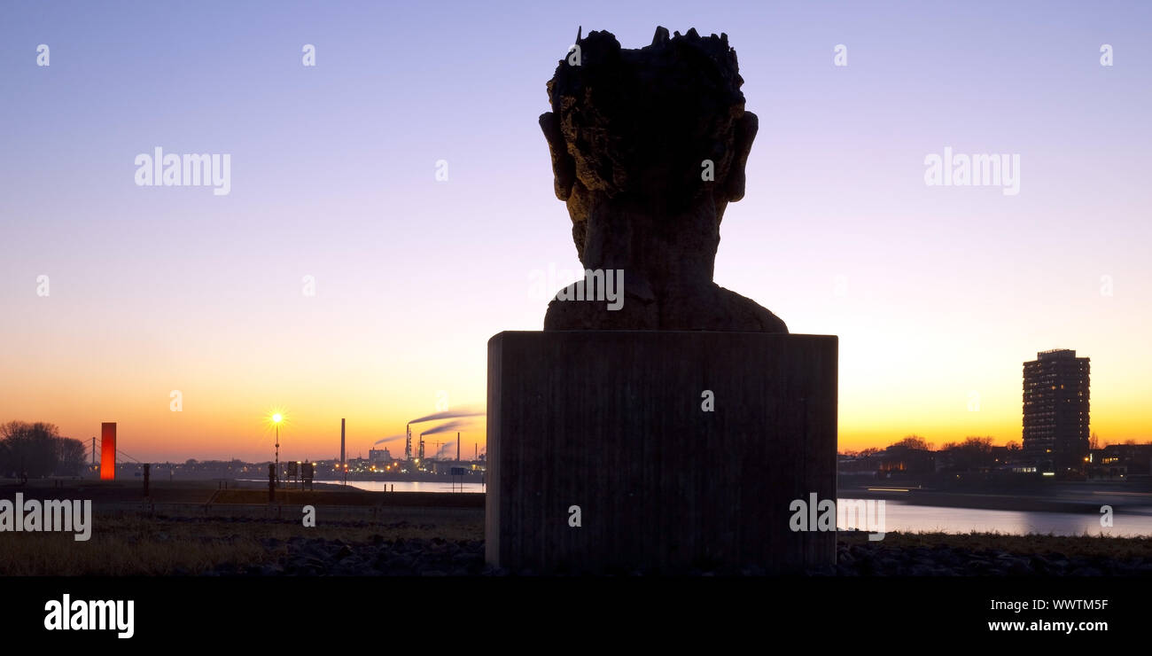 Skulptur Echo des Poseidon bei Sonnenuntergang, Skulptur Rhineorange im Hintergrund, Duisburg, Deutschland Stockfoto