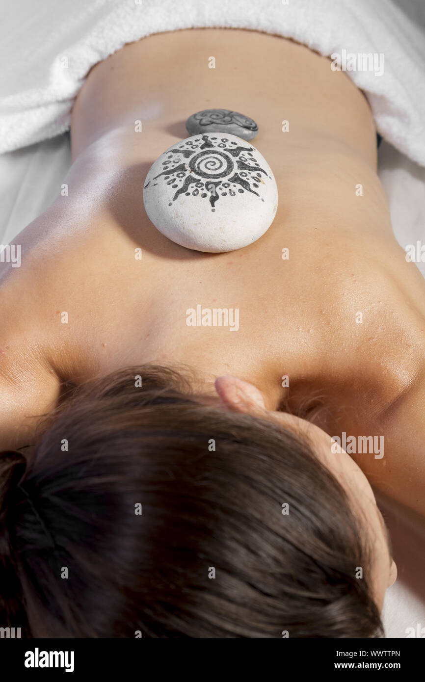 Massage und Entspannung, schöne Brünette Frau entspannen auf einer Bahre, die eine therapeutische Massage von Händen bekennen. Stockfoto
