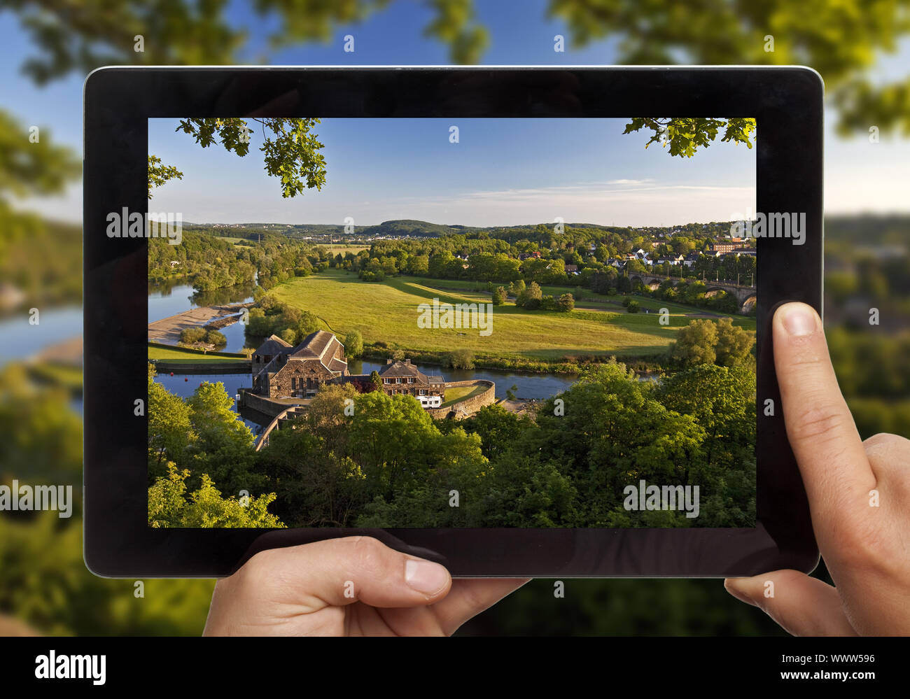 Mit einem Tablet PC in der Hand mit einem Foto aus dem Ruhrgebiet vor der realen Landschaft Stockfoto