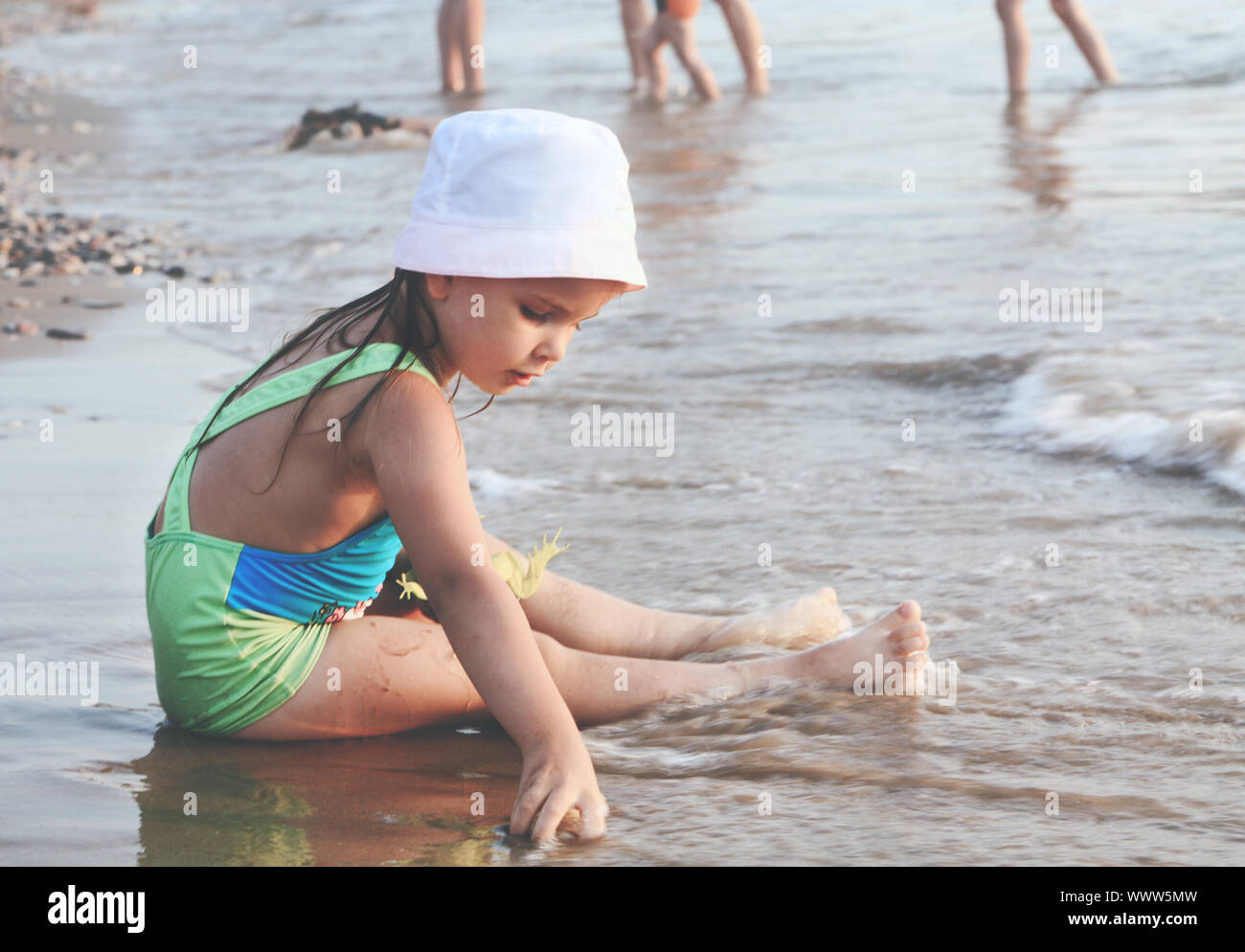 Eine kleine süße Mädchen spielen auf ein Sandstrand. Stockfoto