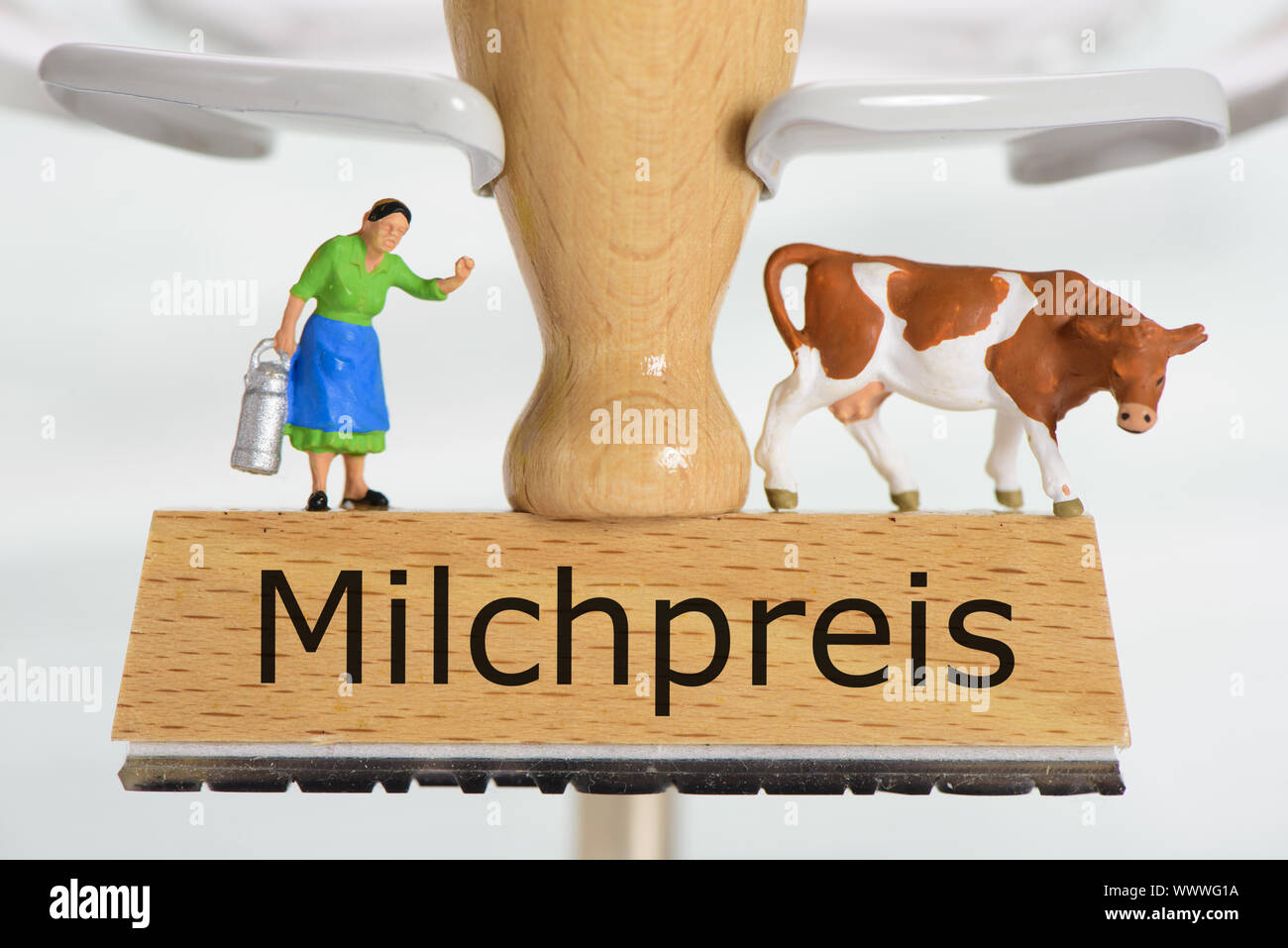 Milch Preis auf hölzernen Stempel mit Bäuerin und Milchkuh Stockfoto